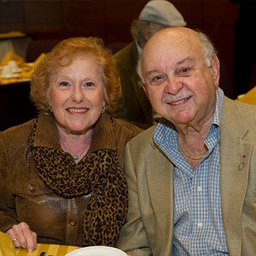 Older couple sitting down together smiling. Read about What to Give