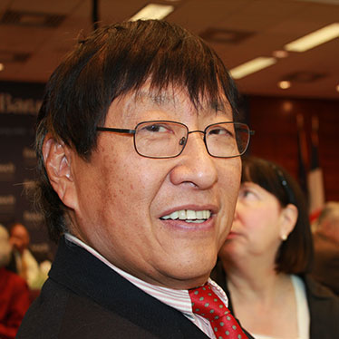 Man in suit and tie smiling at camera. Read about Beneficiary Designations